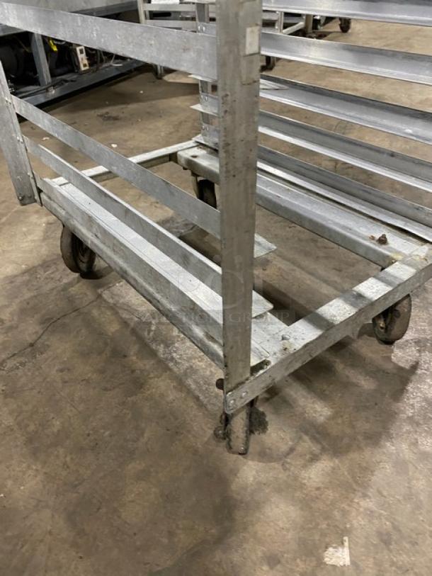 Commercial stainless steel sheet pan rack on casters, minor wear visible, ideal for bakery use, sturdy construction.