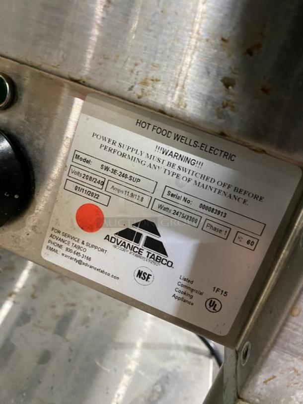 Advance Tabco stainless steel electric 3-pan hot food well, model SW-3E-240-SUP, with single undershelf and cutting board.