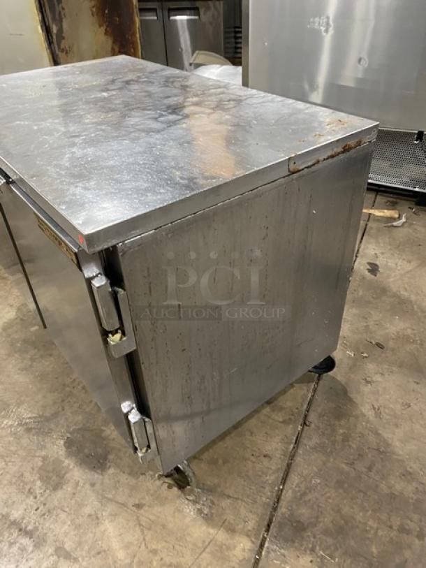 Beverage Air 2-door stainless steel refrigerated worktop cooler on casters, with poly coated wired rack, shows signs of wear.