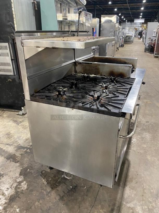 Montague Commercial Stainless Steel 6-Burner Range with 24" Char Broiler and Cheese Melter. Features full-size oven, on casters.