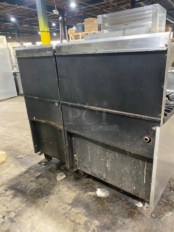 Montague stainless steel natural gas 6-burner range, 24" char broiler combo, cheese melter, full-size oven, on casters.