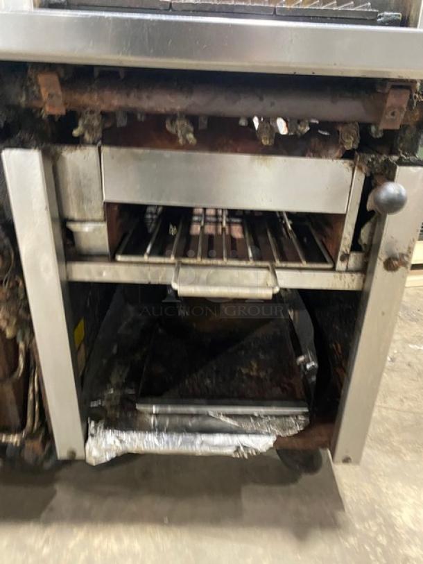 Montague stainless steel natural gas 6-burner range with 24" char broiler, cheese melter, and full-size oven. On casters. Used.