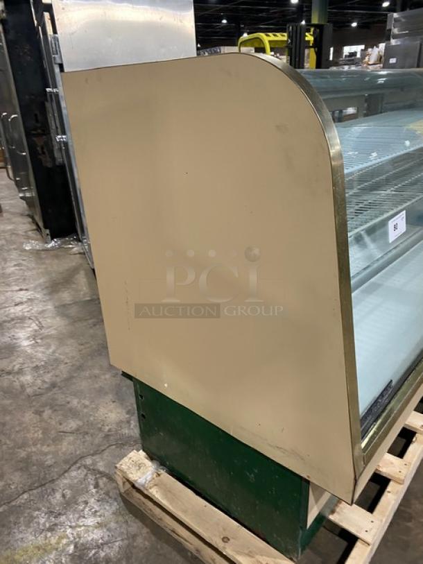 Schmidt commercial curved glass bakery merchandiser with sliding access door and poly-coated wired rack.