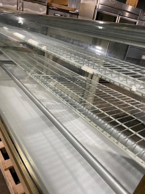 Schmidt curved glass refrigerated bakery display case, multi-tier with poly coated wire racks, rear sliding glass door, commercial use.