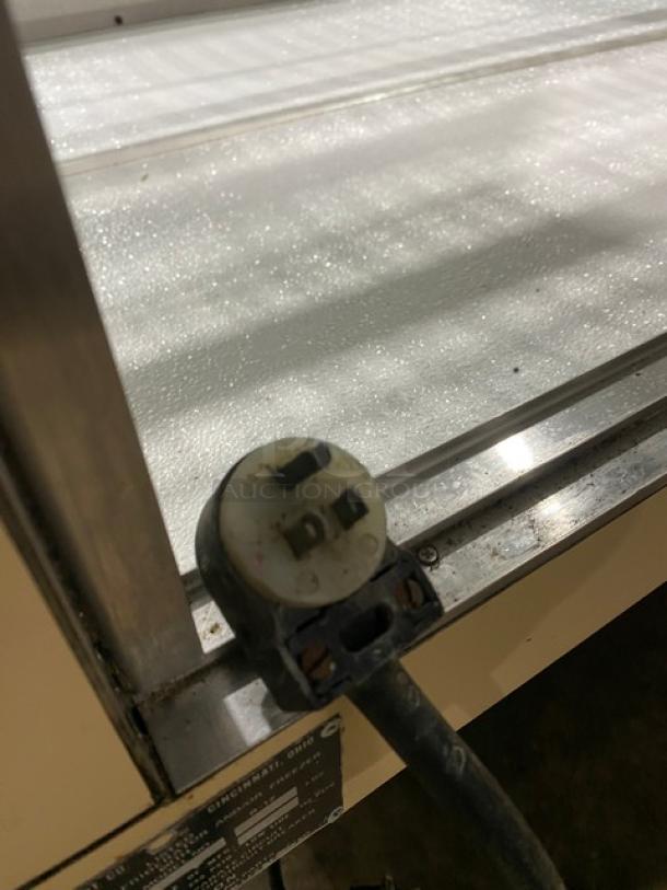 Schmidt curved glass bakery merchandiser displaying interior wiring and plug. Rear sliding glass door and poly-coated rack not visible.