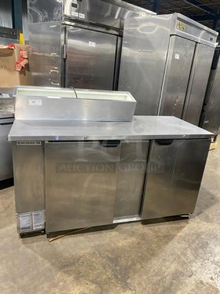Beverage Air stainless steel pizza prep table with extra-large work space, two-door cold storage, poly coated wire rack.
