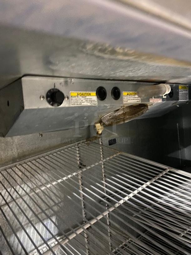 Beverage Air refrigerated pizza prep table, stainless steel, with large workspace, two-door cold storage, poly-coated wire rack.