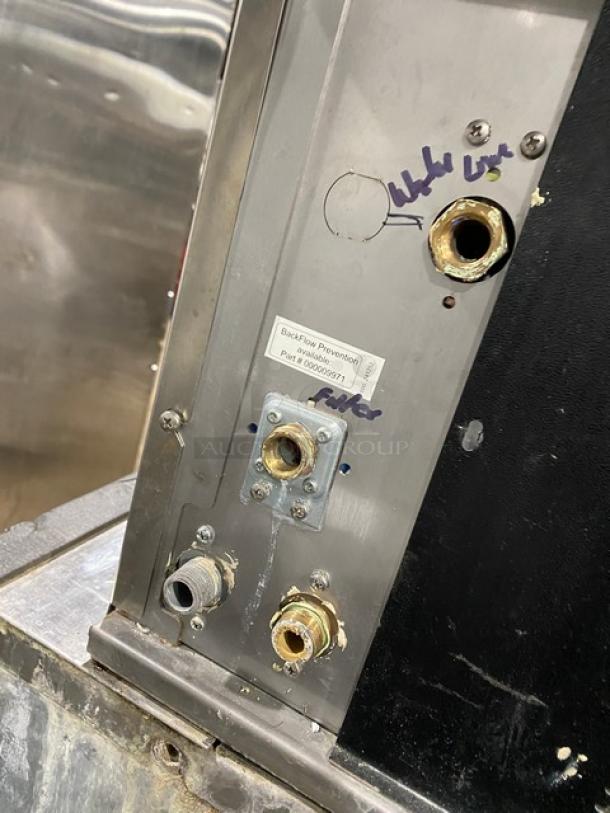 Manitowoc RNF0620W ice machine connections with visible backflow prevention label, model and serial number markings.