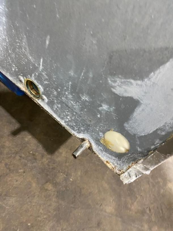 Close-up of Hoshizaki KM1601SWH3 ice machine's side panel, showing a pipe and wear. Metal surface with some discoloration.