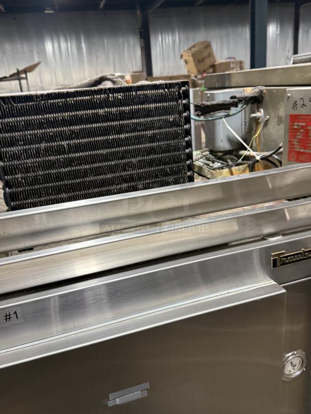 Traulsen 4 split door reach-in cooler with chrome rack shelving, 115V 1 phase, on legs; visible labels and markings.