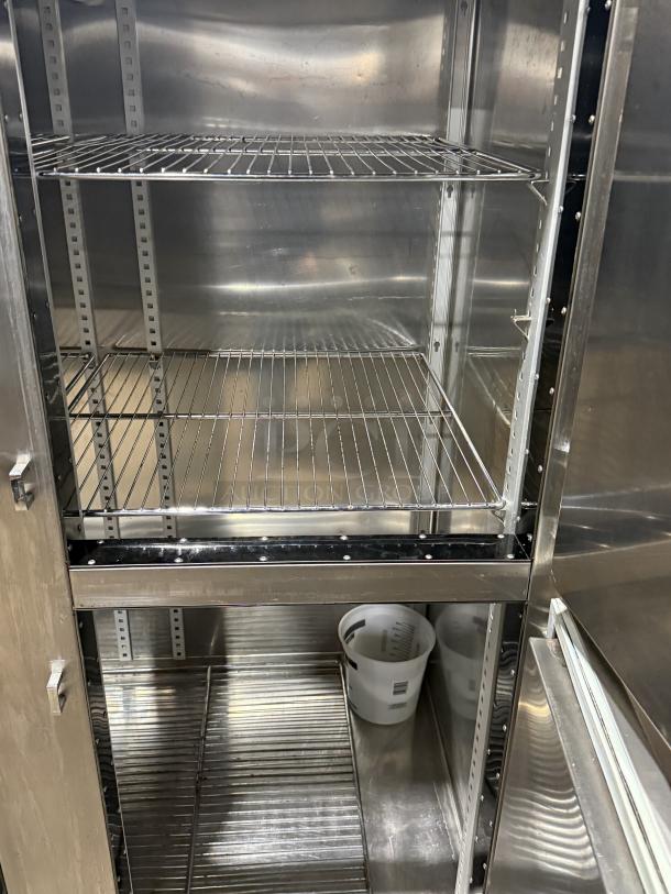 Traulsen 4 split door reach-in cooler with chrome rack shelving and legs, 115V 1 Phase, featuring stainless steel interior.