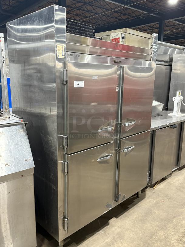 Traulsen 4 split door reach-in cooler with chrome rack shelving, 115V 1 phase, on legs. Model marked "Reach In #1."