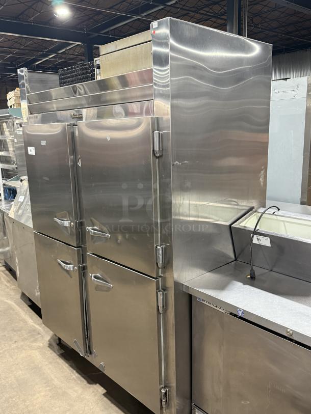 Traulsen 4 split door reach-in cooler with chrome rack shelving, stainless steel finish, on legs, 115V 1 phase, excellent condition.