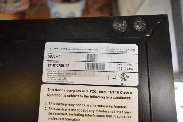 Crane 5800-4 Metal Commercial Bottled Drink Vending Machine with Bill Acceptor, 115 Volts, 1 Phase, includes FCC compliance label.