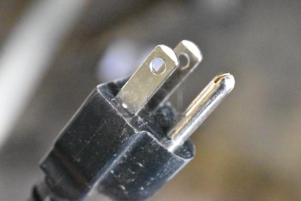 A close-up of a standard two-prong electrical plug for the Hobart HTi-7LH4W scale, showing metal prongs.