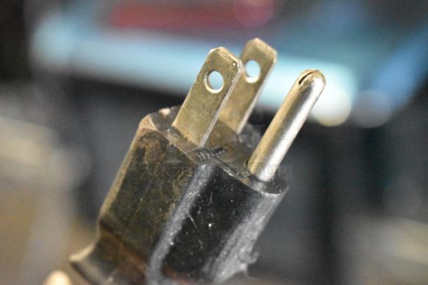 Close-up of a three-prong electrical plug, hints of wear. Appears to be part of 2024 Hobart HTi-7LH4W scale.