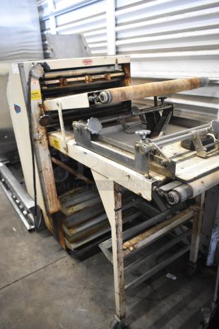 Moline commercial floor-style dough sheeter on casters, rusted, 125 volts, 1 phase, visible wear on rollers and frame.