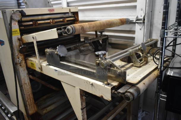 Moline commercial floor dough sheeter on casters, 125V, 1 phase. Visible rust and wear. Various warning labels attached.