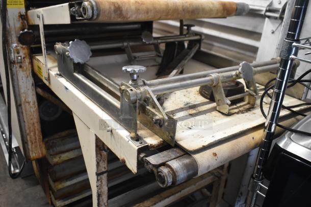 Moline commercial floor-style dough sheeter on casters, 125 volts, 1 phase, shows signs of wear, suitable for bakery use.