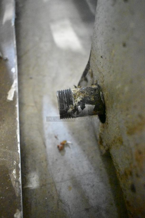 Close-up of a gas fitting on a Wells commercial countertop charbroiler grill, showing signs of wear and rust.