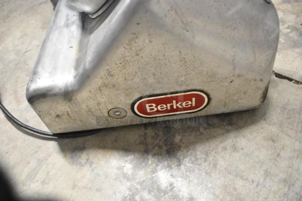 Berkel commercial countertop meat slicer with blade sharpener, 115 volts, 1 phase, visible wear, brand logo displayed.
