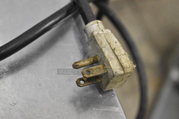 Close-up view of a worn power plug from a Berkel 522 Commercial Countertop Scale. Plug has visible wear marks.