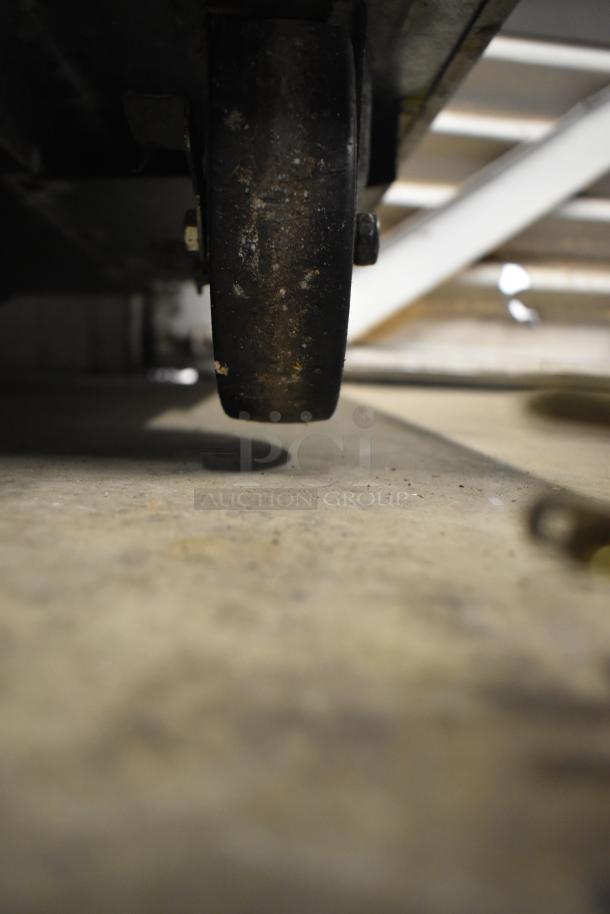 Close-up of a commercial caster wheel from the 2016 True TUC-27F-D-2-HC undercounter freezer, showing wear on the wheel.