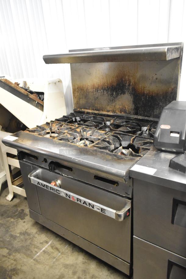 American Range AR-6 commercial gas stove with 6 burners, oven, over shelf, backsplash; visible wear, ideal for high-volume kitchens.