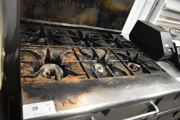 American Range AR-6 commercial gas 6-burner range with oven, over shelf, and backsplash. Shows signs of wear. Model: AR-6.