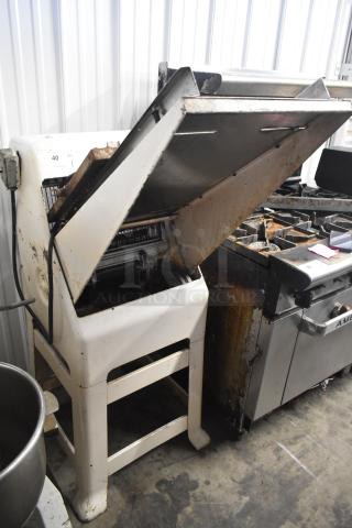 Commercial floor-style bread loaf slicer, 115 volts, 1 phase. Used condition, visible wear. Features adjustable slicing mechanism.
