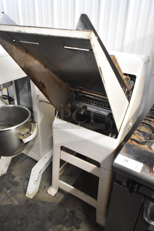 Commercial bread loaf slicer, floor style, 115 volts, 1 phase. Visible wear and rust. Essential for bakery operations.