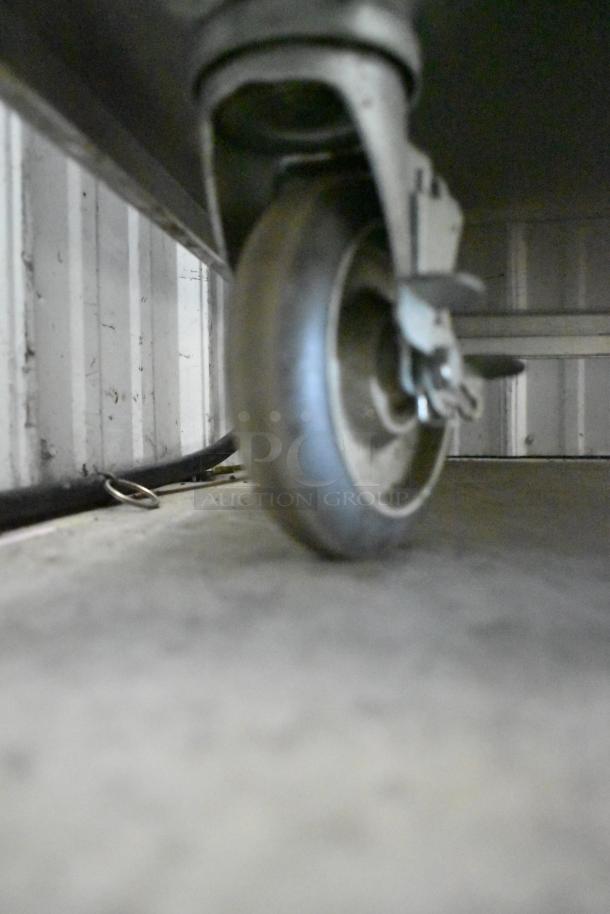 Close-up of a commercial caster on a CresCor H138NPS36CLCMQRL hot food holding cabinet, showing detail and condition.