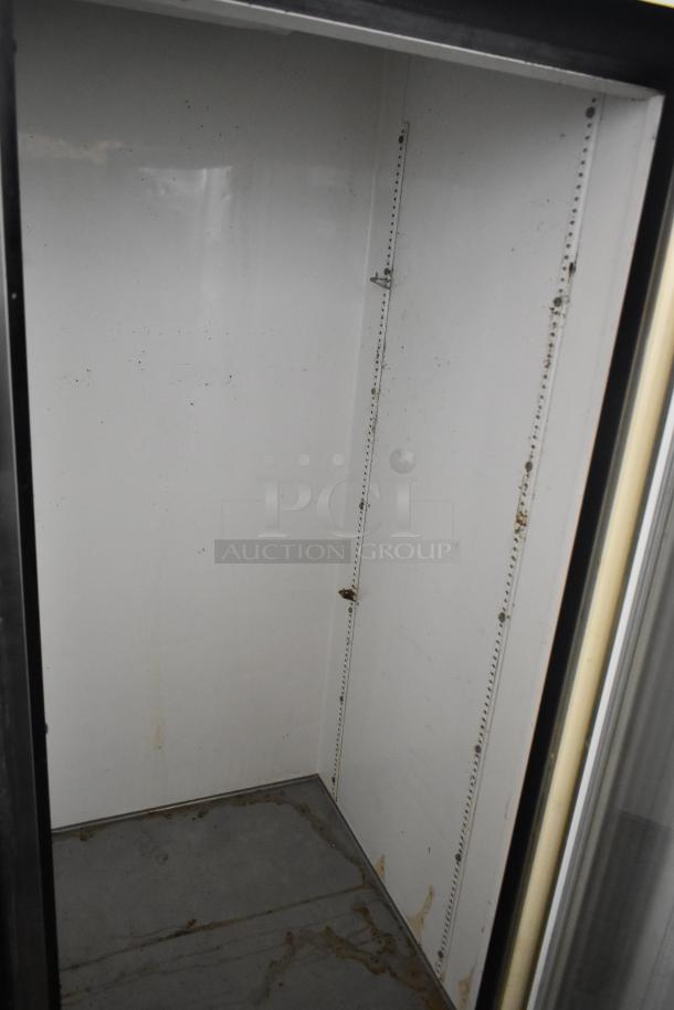 True GDM-49 Commercial 2 Door Reach In Cooler, empty interior, visible shelf brackets, some wear, 115V, 1 Phase.
