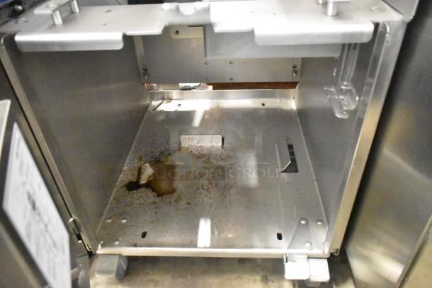 LATE MODEL JBT 2ND-GEN-MFJ-HE citrus juicer interior view, showing wear and residue. Features commercial casters, 115V, 1 phase.