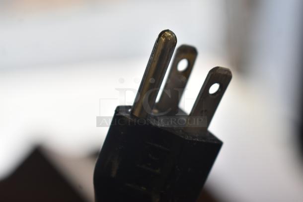 Close-up of a power plug, part of the Hobart HTi-7LH commercial food scale, showing prongs and wiring detail.