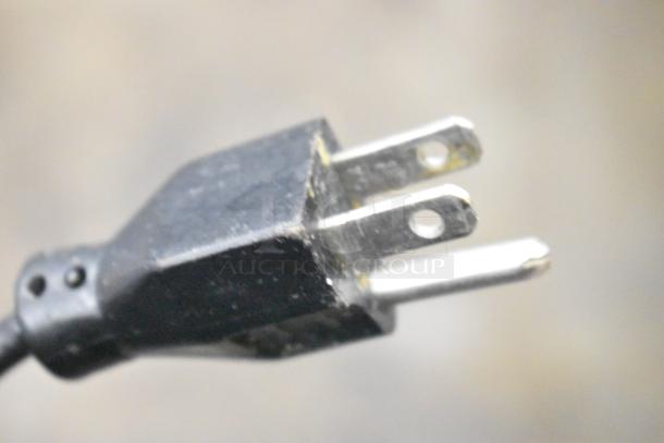 Close-up of a black power plug for the 2016 Hobart HTi-7LH commercial scale, showing prongs.