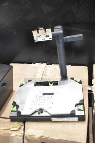 Mettler Toledo FreshWay scale setup, 100-240 volts, 1 phase, visible wiring, handwritten markings on base, on cardboard surface.