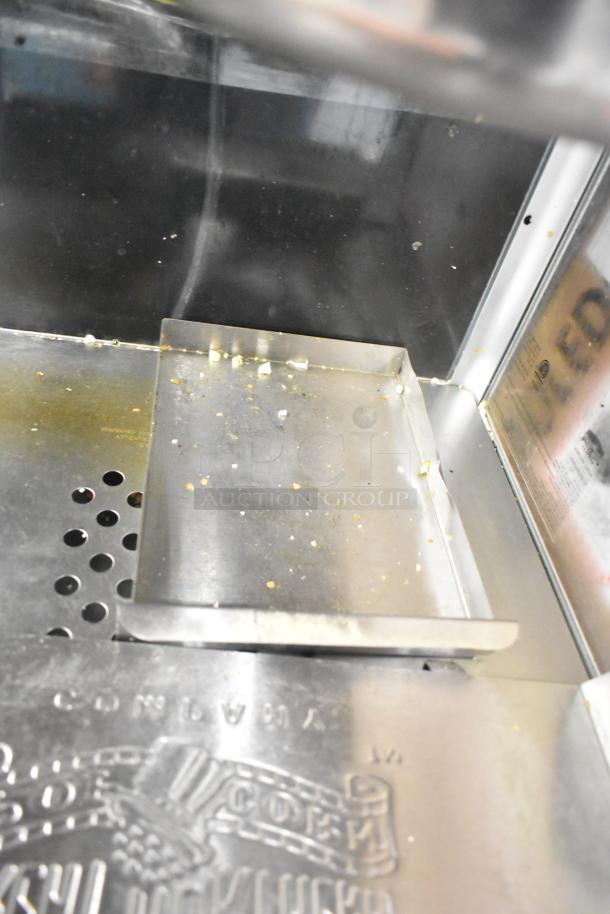 Great Northern Co 83-DT5634 countertop popcorn machine interior; visible residue, model and warning labels.