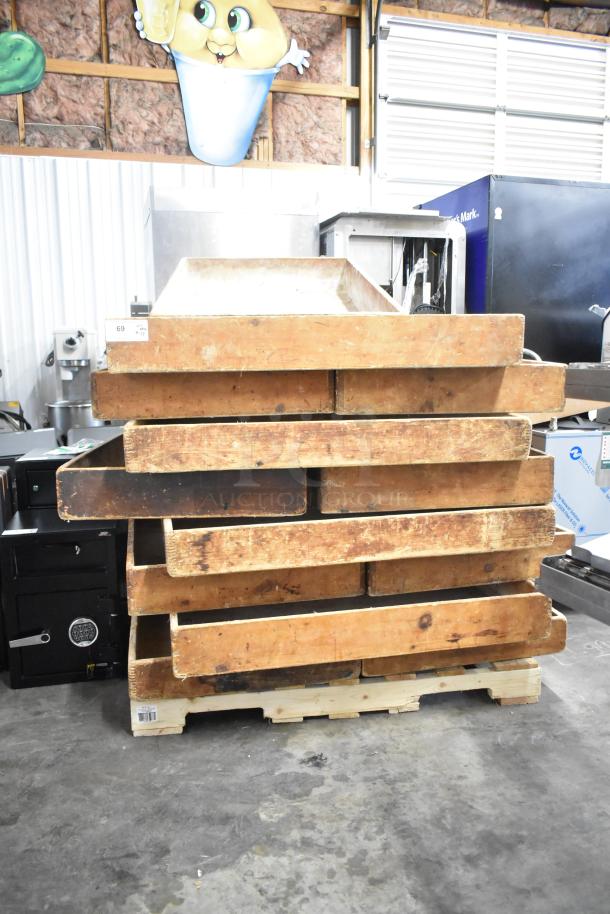 17 various wooden bins stacked on a pallet in used condition. Auction tag visible, numbered 69.