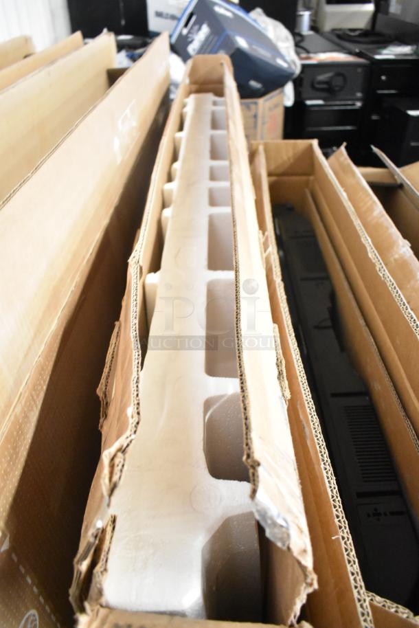 Samsung QM55C 55" TVs in original boxes, protective packaging visible. Buyer must pick up; local auction item.