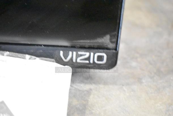 Corner of a Vizio television with a visible logo, showcasing part of the screen.