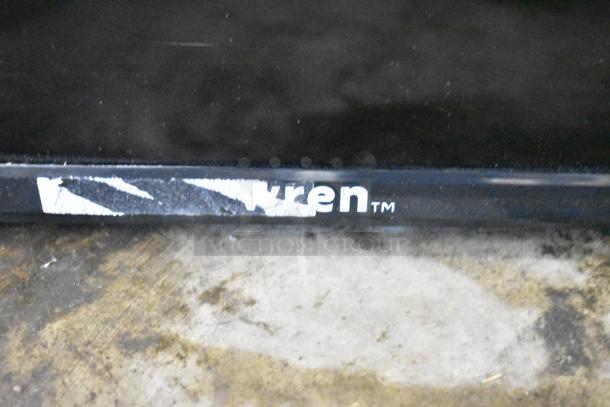 Close-up of a Wren TV brand label on a black frame, showing some wear and scuff marks.