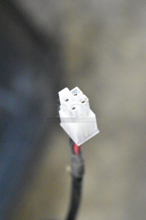 A close-up of a white four-pin connector with attached black and red wires, possibly used for electronic devices.