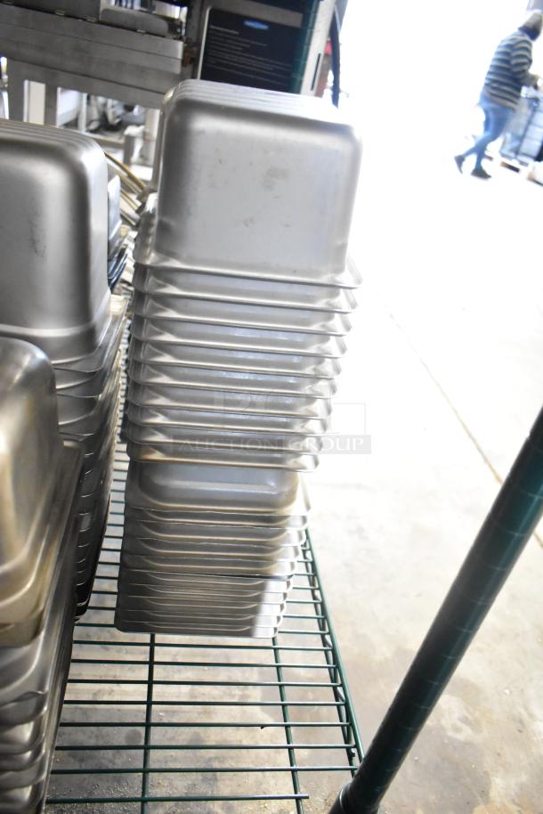 64 stainless steel drop-in bins, various sizes, including 1/3 size, shown stacked on metal rack, used condition.