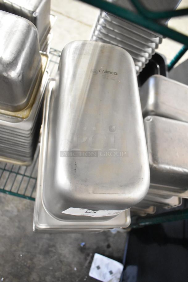 64 various stainless steel drop-in bins, including 1/3 size. Bins feature Winco branding, stacked on a wire rack.
