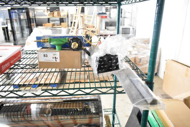 Eight brand new scratch and dent items including Delfield coil evaporator and Watts safety relief valve on shelf with auction tag.