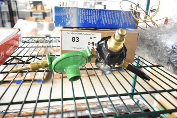 8 brand new scratch and dent items including Delfield evaporator coil, TR36 ticket rack, Watts valve, wires on a shelf.