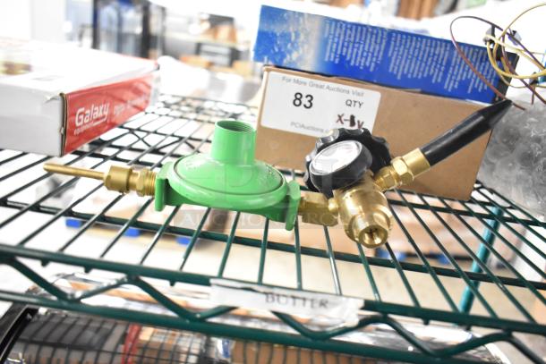 8 brand new items including Delfield 3516298 coil evaporator, TR36 ticket rack, Watts valve, regulator, wires; on a metal rack.