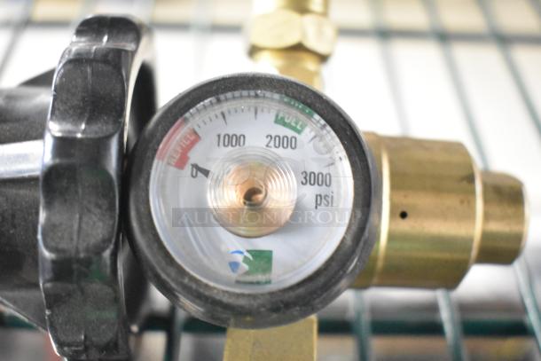 Gauge close-up reading 0-3000 psi on a brass pressure regulator. Includes black adjustment knob. Part of auction item.