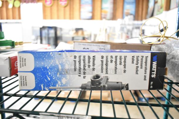Box of Watts Temperature and Pressure Safety Relief Valve on a shelf, new condition, part of an 8-item auction lot.